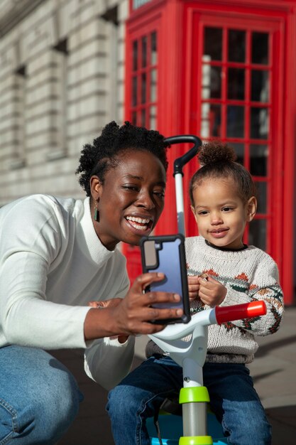 Medium shot woman and kid taking selfie