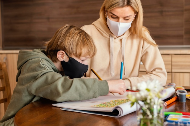 Medium shot woman and kid with mask