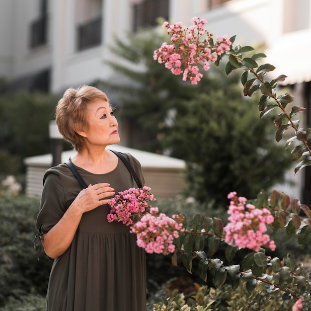 Medium shot woman looking at flowers