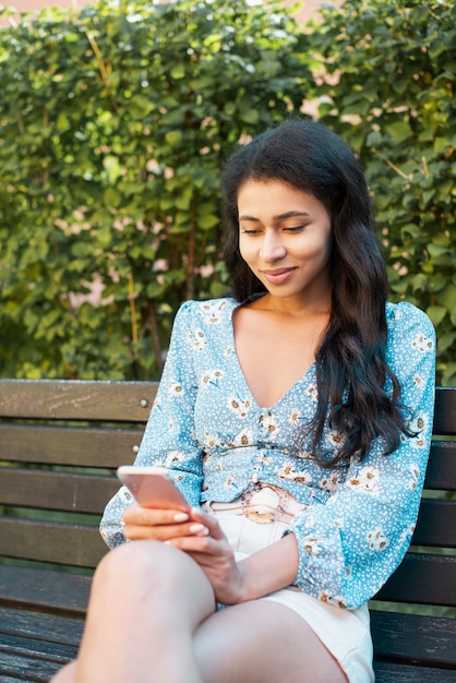 Medium shot of woman looking at her phone