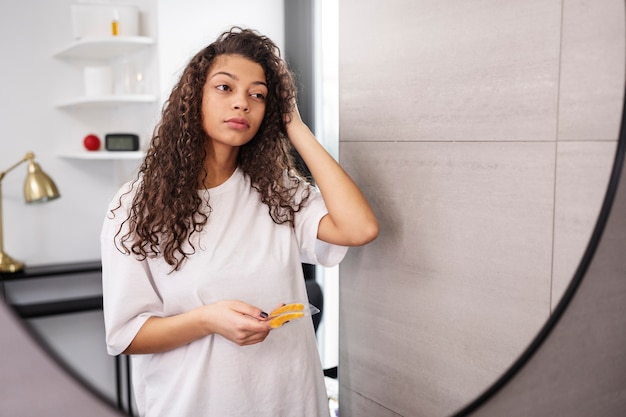 Free photo medium shot woman looking in the mirror