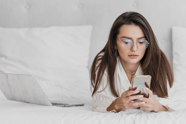 Medium shot woman looking at phone