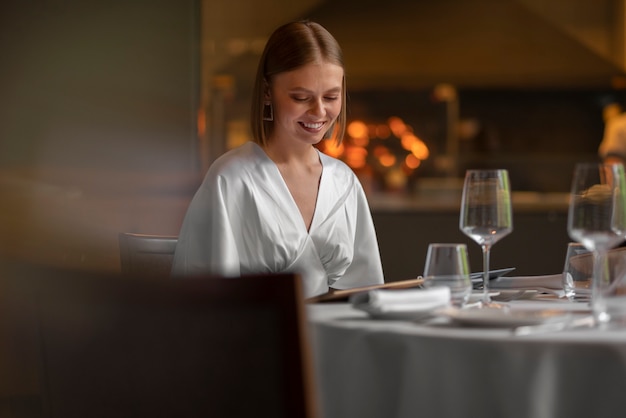 Free Photo medium shot woman in  luxury restaurant