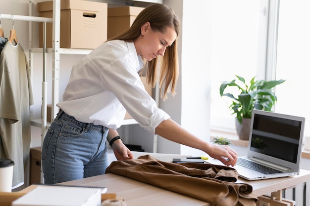 Free photo medium shot woman packing shirt