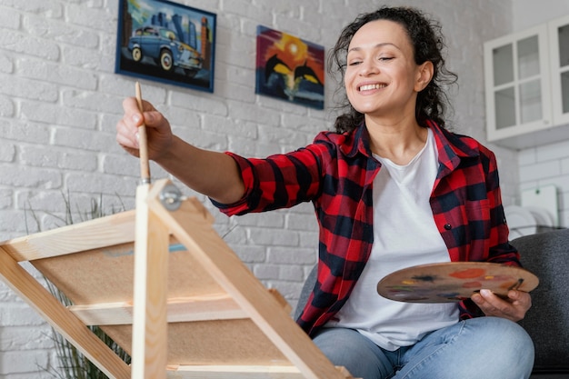 Medium shot woman painting indoors