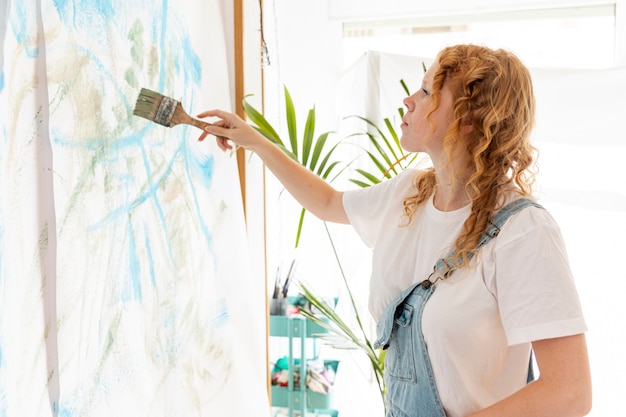 Free Photo medium shot woman painting on the wall