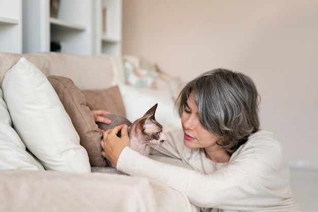 Medium shot woman petting cat