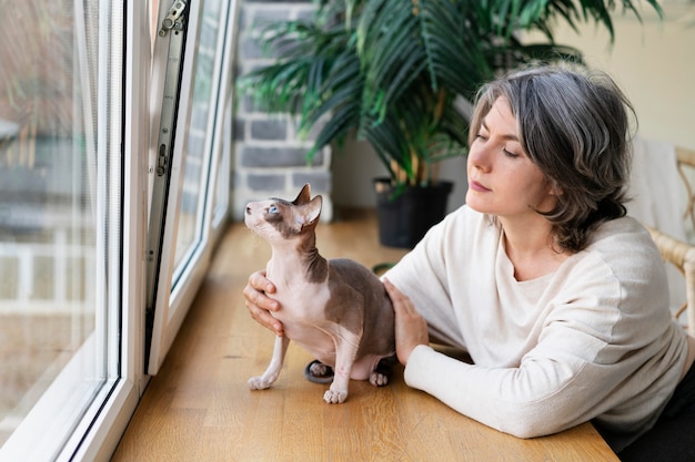 Free Photo medium shot woman petting cat