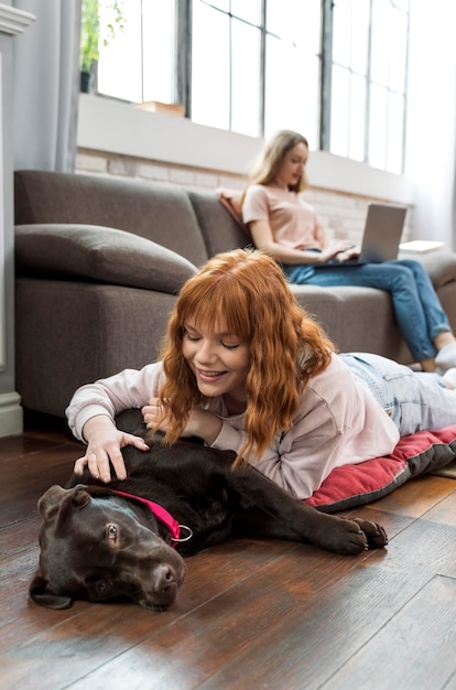 Medium shot woman petting dog on floor