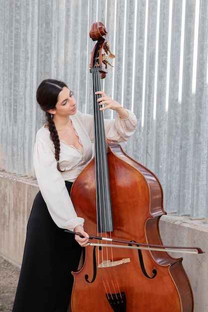 Medium shot woman playing double bass