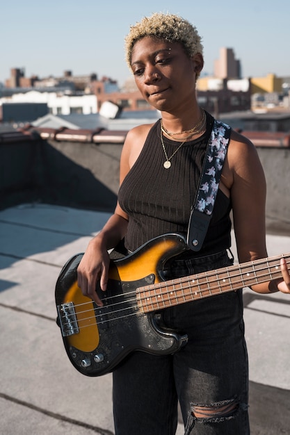 Medium shot woman playing the guitar