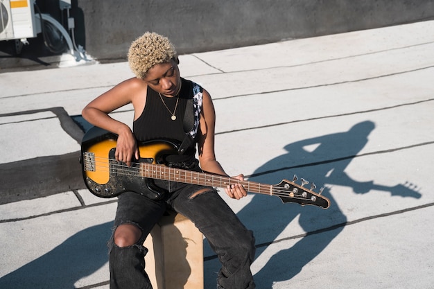 Medium shot woman playing the guitar