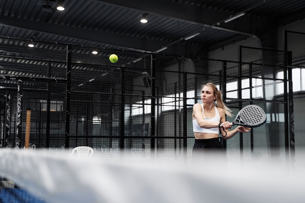 Medium shot woman playing paddle tennis