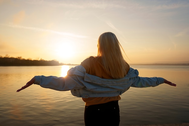 Free photo medium shot woman posing at sunset