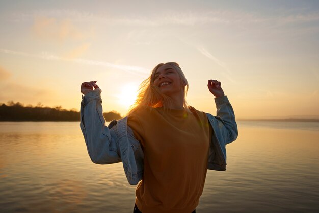 Medium shot woman posing at sunset