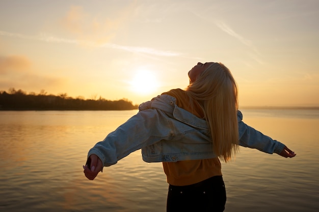 Free photo medium shot woman posing at sunset