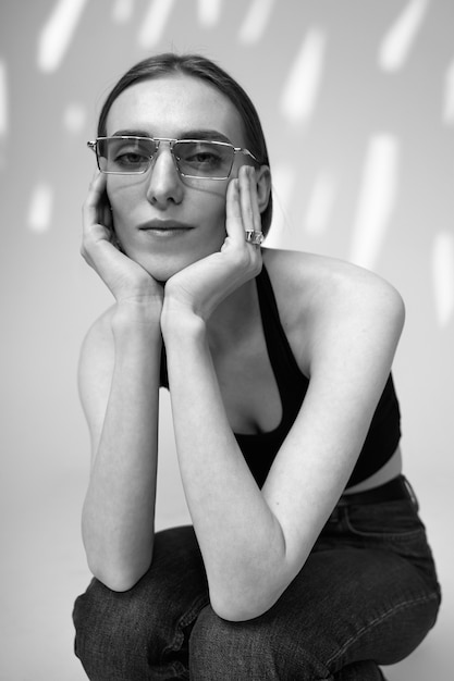 Free photo medium shot woman posing with glasses black and white