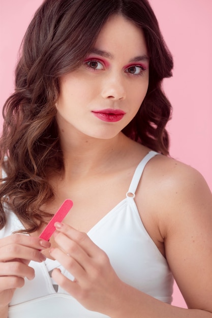 Medium shot woman posing with nail file