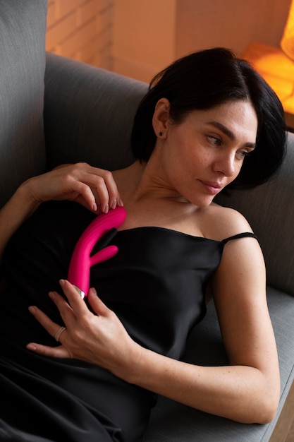 Medium shot woman posing with vibrator