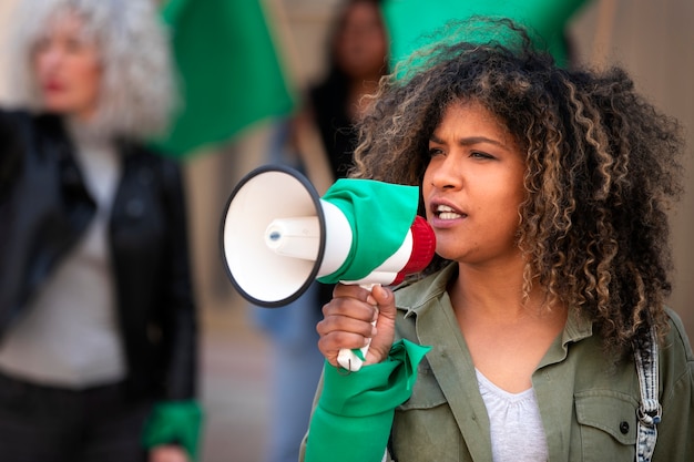 Medium shot woman protesting outdoors