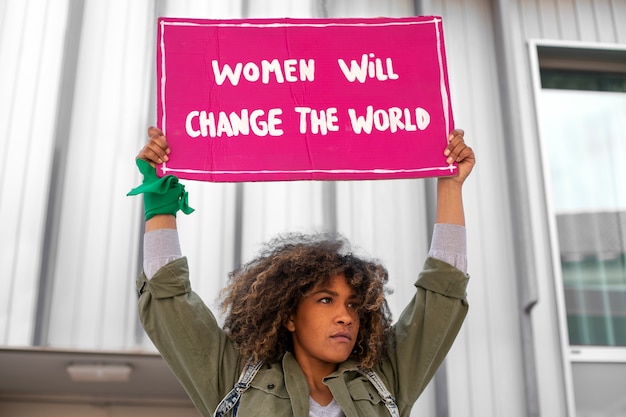 Medium shot woman protesting outdoors