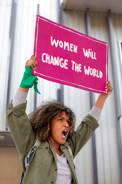 Medium shot woman protesting outdoors