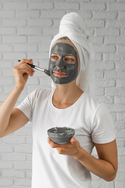 Medium shot woman putting on face remedy