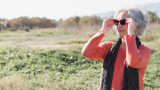 Medium shot woman putting on sunglasses