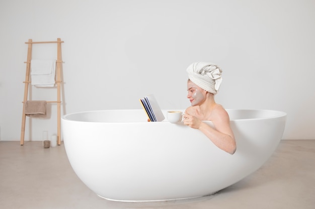 Medium shot woman reading in bathtub