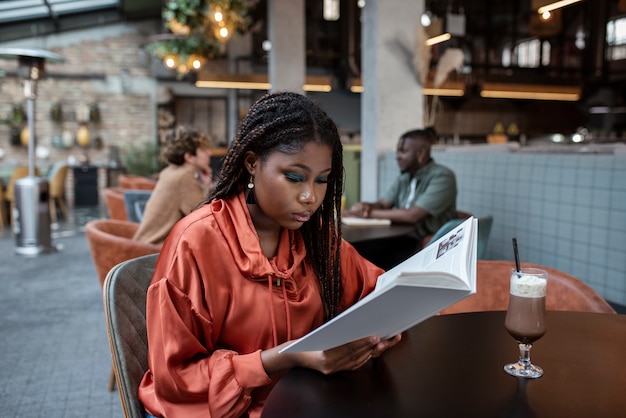 Medium shot woman reading in coffee shop