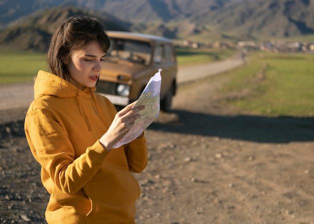 Free photo medium shot woman reading map