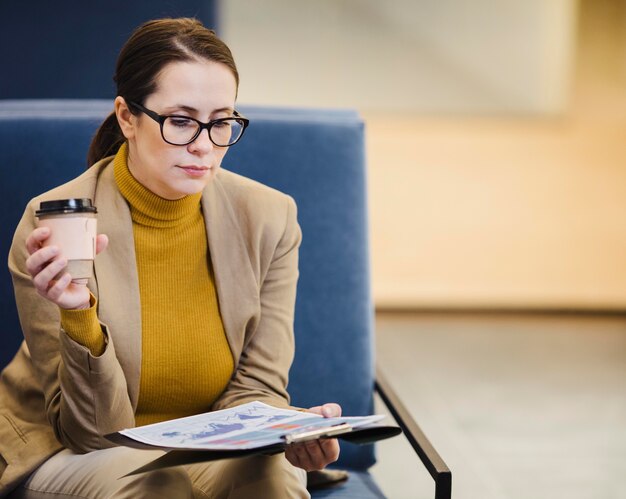 Medium shot woman reading paper