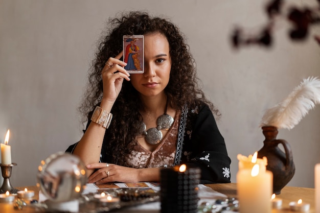 Free Photo medium shot woman reading tarot at home