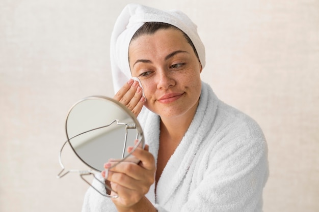 Free Photo medium shot woman removing make-up