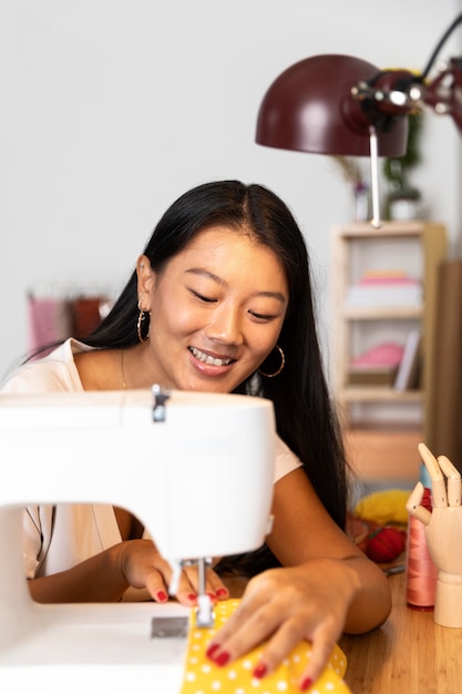 Medium shot woman sewing with machine