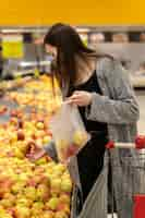 Free photo medium shot woman shopping for fruits