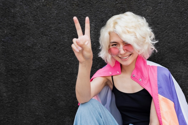 Free photo medium shot woman showing peace sign