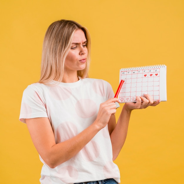 Free photo medium shot of woman showing the period calendar