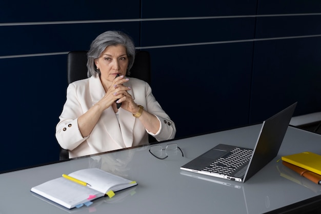 Medium shot woman sitting at desk