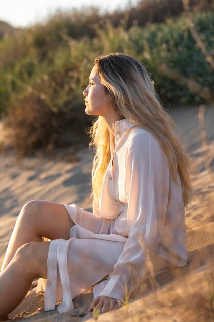 Medium shot woman sitting on sand