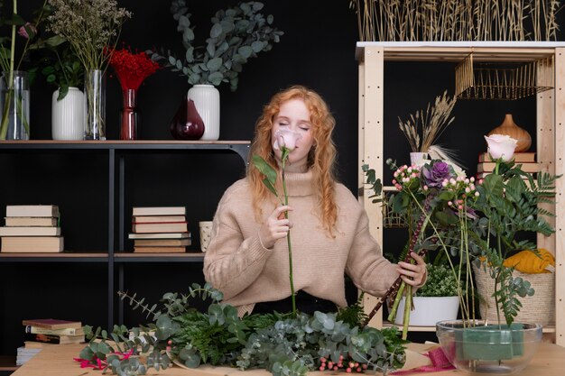 Medium shot woman smelling flower