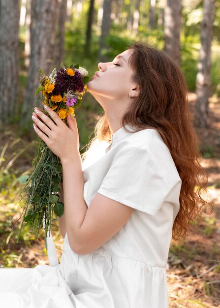 Medium shot woman smelling flowers