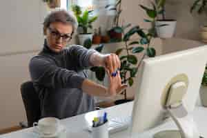 Free photo medium shot woman stretching at desk