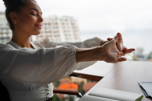 Free Photo medium shot woman stretching at work