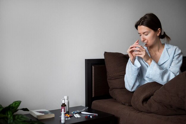 Medium shot woman taking medicine