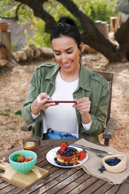 Medium shot woman taking photos of dessert