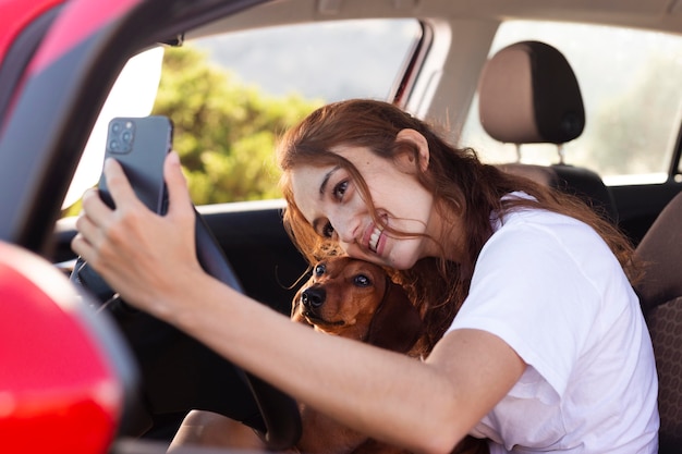 Free Photo medium shot woman taking selfie with dog