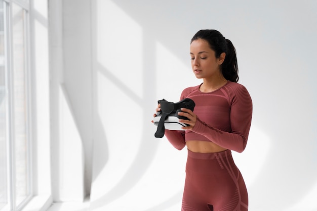 Medium shot woman training with vr glasses on