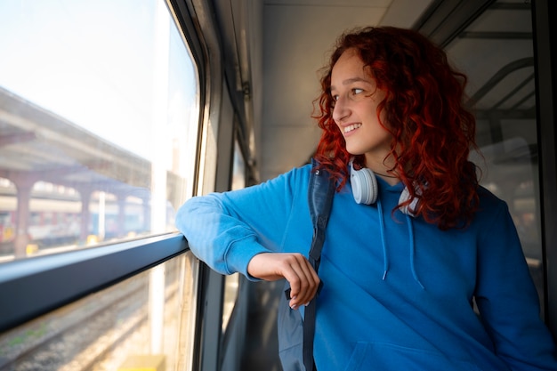 Free photo medium shot woman traveling by train