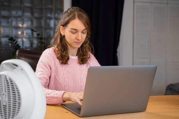 Medium shot woman typing on laptop